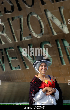 lächelnde Frau im traditionellen Kostüm außerhalb Millenium Centre Welsch Stockfoto