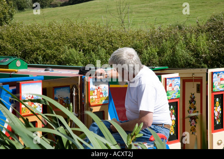 Wiederherstellung der traditionellen Lackierung auf ein Grachtenboot auf der Kennet und Avon Kanal bei vertreibt Green in der Nähe von Devizes in Wiltshire Stockfoto