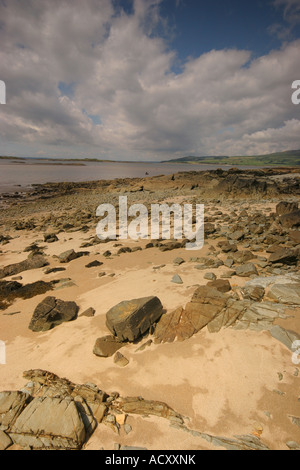 Blick entlang der Galloway-Küste, gesäumt von Felsen, Geröll und feinem Sand zu den entfernten Hügeln jenseits Stockfoto