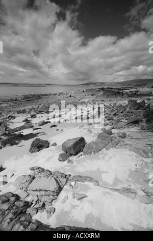 Blick entlang der Galloway-Küste, gesäumt von Felsen, Geröll und feinem Sand zu den entfernten Hügeln jenseits Stockfoto