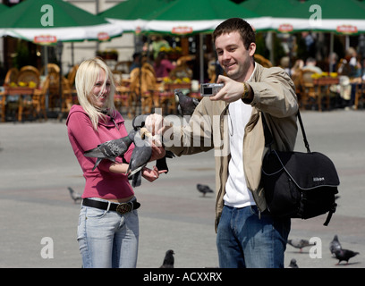 Junges Paar füttern Tauben in den Hauptmarkt in Krakau, Polen Stockfoto