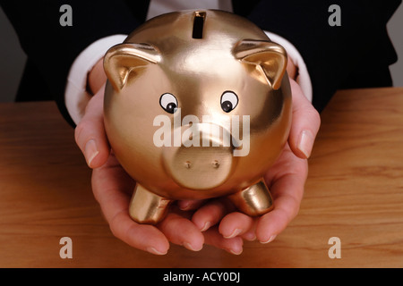 Frau Holding goldene Sparschwein Stockfoto
