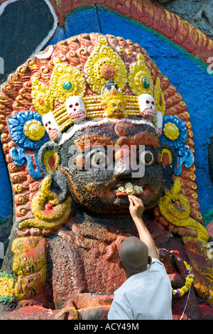 Mann eine Darbringung Kala Bhairab Gott. Durbar Square.Kathmandu.Nepal Stockfoto