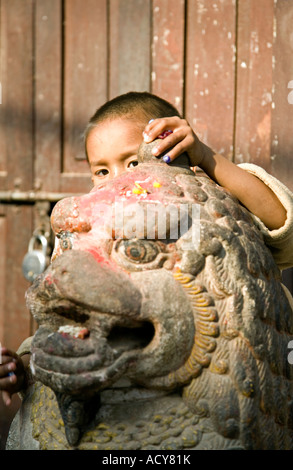 Nepali Boy und Löwe Statue [Bearbeiten] Bhimsen Tempel. Kathmandu. Nepal Stockfoto