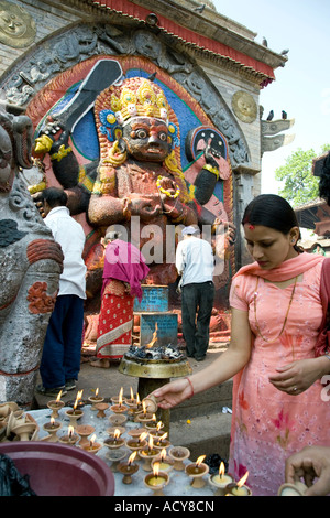 Frau Beleuchtung Butterlampen für Kala Bhairab. Durbar Square. Kathmandu. Nepal Stockfoto