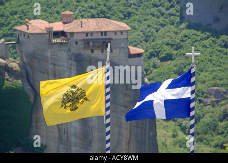 Nationale Griechische und Griechisch-orthodoxe Kirche Flagge auf dem Hügel Kloster Blick über das Fliegen zu ähnlichen Kloster auf Rock pinnacle Meteora Kalambaka Griechenland Stockfoto