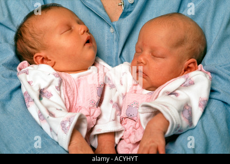 Eine Mutter wiegt ihr zwei 2 - Wochen alten Zwillingsmädchen. Stockfoto