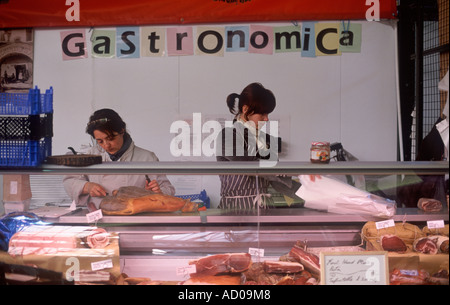 Prosciutto Crudo, Pancetta und Speck – Frau schneiden getrockneten Schinken Tresen der italienischen Delikatessen im Borough Market, London Stockfoto