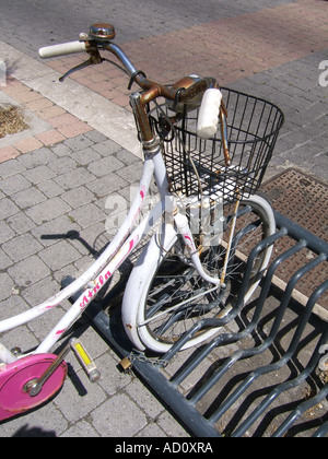 ein altes Fahrrad geparkt am Stand in der Stadtstraße Stockfoto