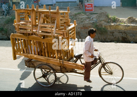 Horizontalen Blick auf eine typische indische inzwischen mit einem indischen Mann seiner überladenen Rikscha entlang der Straße in die Pedale. Stockfoto