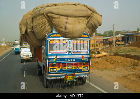 Horizontale Sicht auf eine typische Szene in Indien mit einem LKW überladen mit Fracht Reisen entlang der Straße. Stockfoto