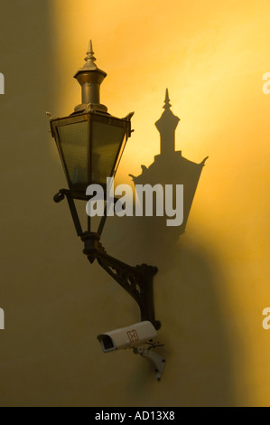 Vertikale Nahaufnahme von eine alte altmodische Schmiedeeisen Lampe wirft einen Schatten auf die Wand Stockfoto