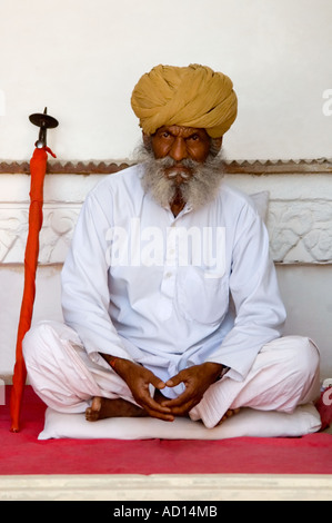 Vertikale Porträt eines traditionell gekleideten indischen Gentleman mit einem großen Turban und großen, buschigen Schnurrbart sitzt im Schneidersitz Stockfoto