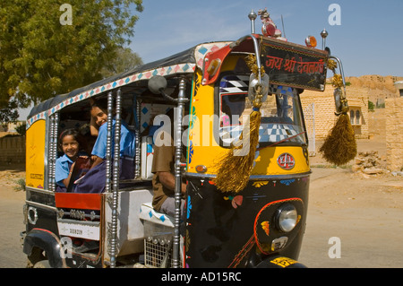 Horizontale Ansicht vieler jungen indischen Schulkinder Ccrammed in einer motorisierten Rikscha nach einer Mitfahrgelegenheit nach Hause von der Schule. Stockfoto