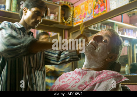 Horizontale Nahaufnahme eines Bewohners des Westens mit einem "Kehle" Rasiermesser rasieren in einem indischen Barbiere Stockfoto