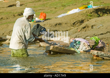 Horizontale Porträt eines indischen Mannes "Dhobi Wallah" Waschen Wäsche in der Nähe von Kedar Ghat in das heilige Wasser des Flusses Ganges Stockfoto