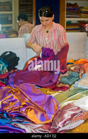 Vertikal nah Qual der Wahl eines westlichen Touristen überschwemmt mit verschiedenen bunten Seide Saris in einem Geschäft. Stockfoto