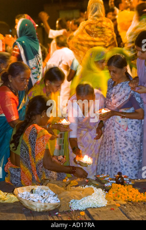 Vertikale Nahaufnahme von indischen Frauen kaufen Blumen Girlanden und Kerzen "Diyas" während der religiöse Gebete "Aarti' am Ganges. Stockfoto