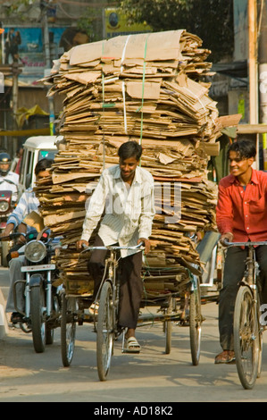 Vertikale Ansicht von einem Rikscha-Fahrer, Radfahren durch die Straßen überlastet mit Pappe bereit für das recycling Stockfoto