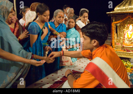 Am Ende des täglichen Aarti (Gebete) an das Dasaswamedh Ghat Opfergaben Sie symbolische an die jungen Priester (Pujaris). Stockfoto