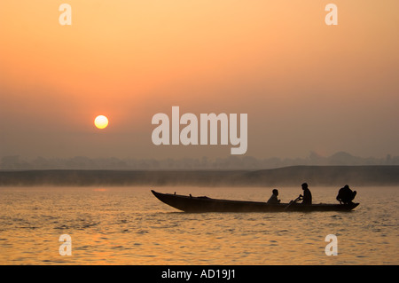 Sonnenaufgang über dem Fluss Ganges (Ganga) mit einheimischen Männer Angeln und Silhouette gegen die aufgehende Sonne. Stockfoto