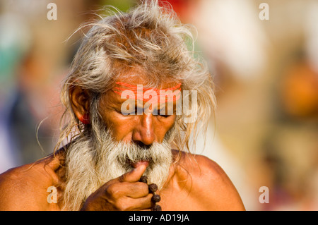 Nahaufnahme von einer älteren grauen Haaren Pilger in Gebet oder Meditation in einem Ghat in Varanasi. Stockfoto