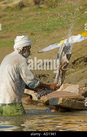 Eine Mann (Dhobi Wallah) wäscht Wäsche in der Nähe von Kedar Ghat in Varanasi. Stockfoto