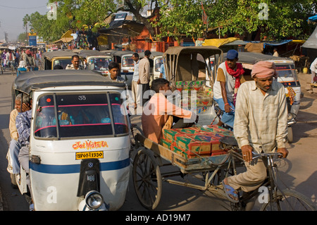 Eine typische chaotischen Straßenszene in Varanasi mit Fahrrad- und Auto-Rikschas (Tuk Tuks) auf den belebten Straßen. Stockfoto