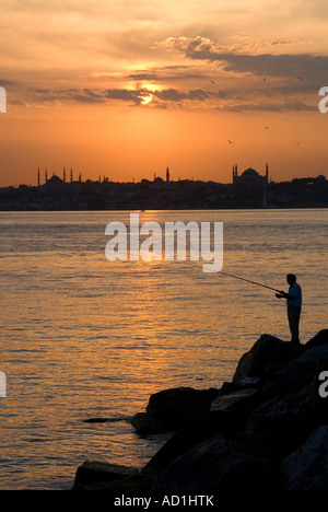 Fischer bei Sonnenuntergang auf Asien Seite über Bosporus von Aya Sofya und Skyline von Istanbul, Türkei Stockfoto