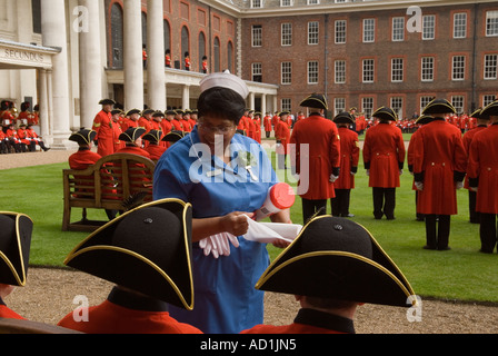 Eine Krankenschwester bringt Tücher für heiße und müde Chelsea Rentner beim Gründungstag Jahresfeier London SW3 2006 2000er HOMER SYKES Stockfoto