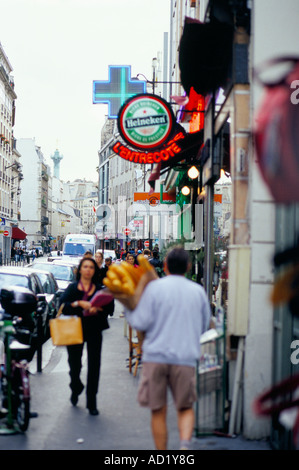 Shopper und ein Mann mit französischen Baguettes auf Rue De La Roquette in der Bastille-Viertel von Paris Frankreich Stockfoto