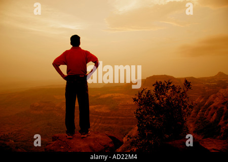 SSK71705 indischer Mann im roten t-Shirt Twilight Blick auf Landschaft in der Nähe von Lonavla Maharashtra, Indien Stockfoto