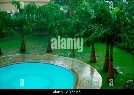 SSK71706 A swimming pool amidst lush green surroundings rain Stockfoto