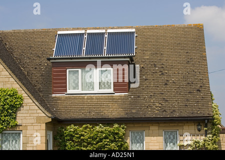 Drei moderne thermische Sonnenkollektoren mit Vakuumröhren auf Dach des Einfamilienhauses Cotswolds UK Stockfoto