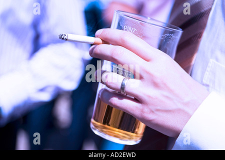 Schuss der junge Geschäftsmann genießen einen Drink und eine Zigarette zur Mittagszeit in der City of London hautnah Stockfoto