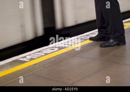 Junger Geschäftsmann steht auf London Underground-Plattform als u-Bahn Station betritt Stockfoto