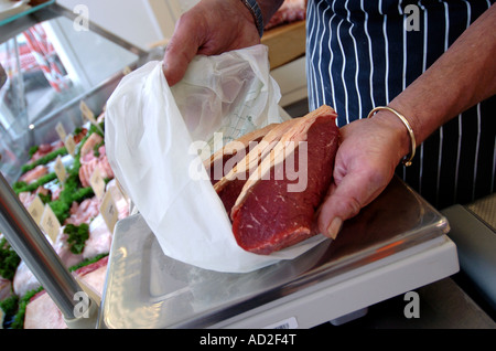 Metzger nutzt Papier und Mais-Stärke-Taschen, wickeln treffen sich in einem Kunststoff-Tasche free Shop in Modbury, Devon Stockfoto