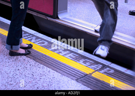 Junger Mann Schritte aus Rohr Zug auf London Underground-Plattform Stockfoto