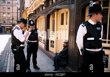 Metropolitan Polizisten, die Überprüfung der Identität eines Menschen sitzen vor einem Pub in Soho London Großbritannien England UK Stockfoto