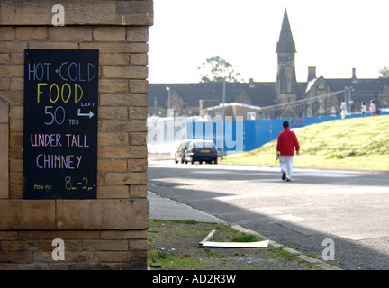 Essen anmelden Bradford mit jungen zu Fuß in Hintergrund in rotes top Stockfoto