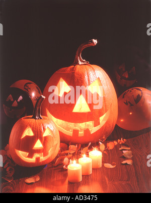 Halloween-Szene mit zwei geschnitzte und beleuchtete Jack O Lanterns mit Votiv-Kerzen und Luftballons Stockfoto