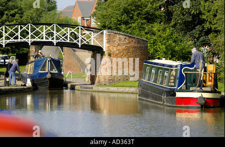 Narrowboats verhandeln die Sperre bei Hawkesbury Junction, North Oxford Canal, England, UK Stockfoto