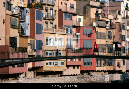 Eine Fußgängerbrücke über den Fluss Onyar, im Herzen von Girona, unterstützt durch eine bunte Palette von mehrstöckige Häuser. Stockfoto