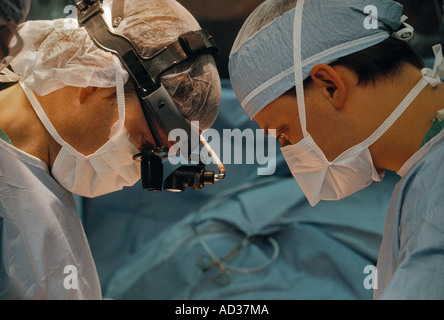 Zwei Peelings und Masken tragen Chirurgen operieren in einem OP-Saal. Stockfoto