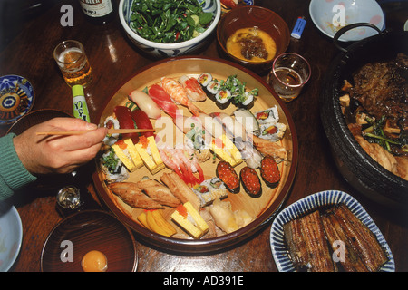 Verwendung von Essstäbchen, Sushi und verschiedene japanische Lebensmittel zu essen Stockfoto