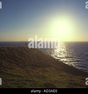 Auf Baggy Punkt stehende Person blickt auf das Meer in der späten Nachmittagssonne auf der Küste von North Devon England britischen Inseln Stockfoto