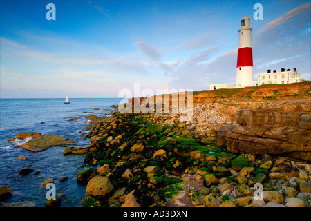 Portland Bill Leuchtturm in der Dämmerung von der Klippe über dem tückischen Landspitze Felsen an der Küste unten Stockfoto