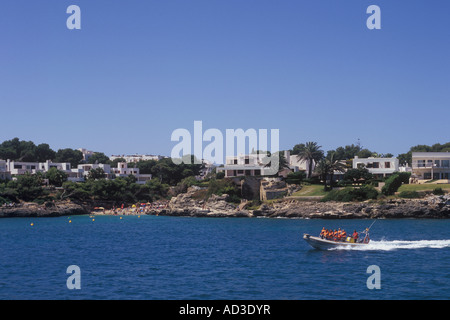 Blick nach Süden in der Nähe von Cala d ' or Yachthafen - mit Seaward hoch gebunden beschleunigen Sea Rider RIB vorbei an Küsten Luxusimmobilien und die Stockfoto