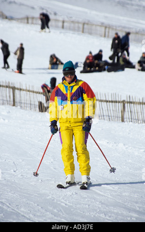 MORAY Schottland UK Februar Mann in einem hellen Gelb Skianzug Skifahren nach unten auf die Pisten im Lecht Ski Centre Stockfoto