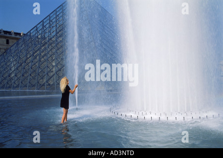 Frau stehend in den Brunnen am Louvre-Palast-Museum in Paris Stockfoto